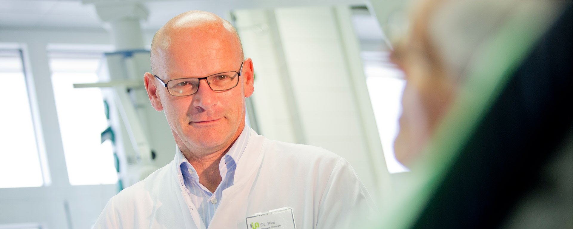 Dr. med. Gerhard Piel, Leiter der Sektion Gefäßchirurgie an der Klinik Mindelheim, führt eine Untersuchung am Bein einer Patientin durch